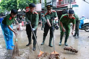 Lực lượng chức năng hỗ trợ người dân khắc phục bùn đất tại các điểm ngập do nước lũ, ngày 24-8. Ảnh: Công an tỉnh Lạng Sơn