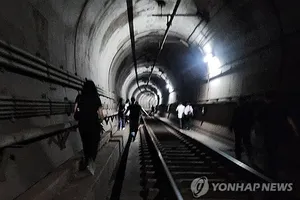 Hành khách toa xe điện ngầm thoát ra qua đường hầm. Ảnh: YONHAP