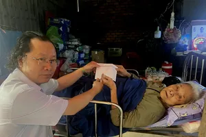 Đại diện Báo Sài Gòn Giải Phóng trao tiền bạn đọc hỗ trợ cụ bà Vũ Thị Tân.