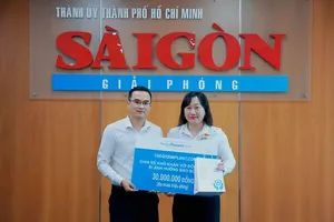 Bà Bùi Thị Hồng Sương, Phó tổng Biên tập Báo Sài Gòn Giải Phóng tiếp nhận 30 triệu đồng chia sẻ khó khăn với đồng bào bị ảnh hưởng bão số 10 (Bualoi) từ ông Nguyễn Thanh Hiền, Giám đốc điều hành Thegioiimplant.com Ảnh: VIỆT NGA 
