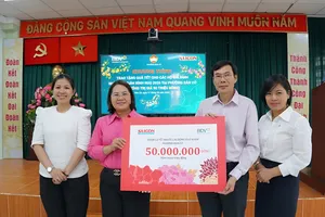 Nhà báo Phạm Văn Trường và bà Bùi Phương Nga trao bảng tượng trưng cho lãnh đạo Ủy ban MTTQ Việt Nam phường Bàn Cờ. Ảnh: VIỆT NGA
