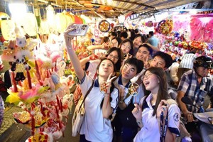 年轻人在梁汝学花灯街打卡。 