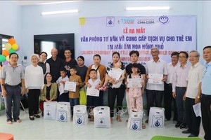 胡志明市儿童权益保护协会主席梁氏顺向有特殊环境的儿童赠送礼物。 