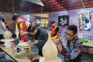钵场陶瓷村陶瓷工艺师在钵场陶瓷村和万福丝织村加入全球创意城市网络“手工艺之都”证书授予仪式暨2025年河内手工艺品展示、演示与创作活动上介绍其村产品。 