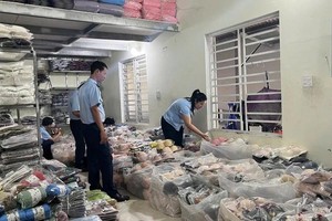 4号市场管理队干部在N.V.H.的经营场所检查货物。