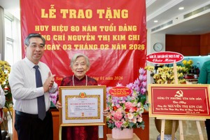 胡志明市市委副书记阮福禄向阮氏金芝同志颁授党龄纪念章并赠送鲜花祝贺。