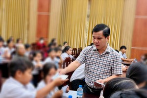 濠庄乡党委书记潘克维向贫困儿童赠送春节礼物。