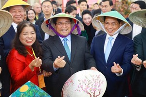 政府总理范明政参观2026年首届春季博览会的工艺美术展位。图自越通社