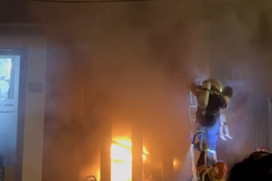 警察在熊熊燃烧、浓烟弥漫的房屋中救出4人。 