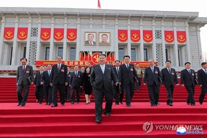 朝鲜国务委员会委员长金正恩（前一）离开会场。