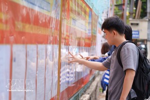 大学生正在研究学校张贴的候选人名单。