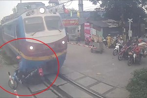 摩托车司机在列车驶来时故意穿越铁路。