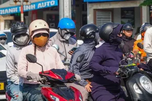  在炎热天气下，市民全副武装位于岘港市和强坊八月革命-和春桥四岔路口停车。