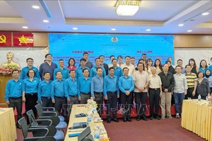 胡志明市劳动联团与新加坡全国职工总会（NTUC）代表们在会议上合影留念。