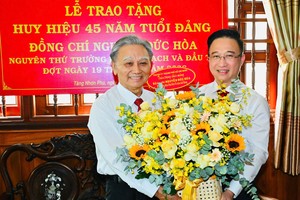 胡志明市市委副书记邓明通向党员阮德和颁授2026年5月19日期党龄纪念章。