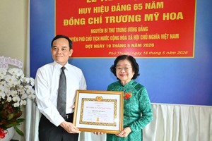  胡志明市市委书记陈留光向张美华同志颁授65年党龄纪念章。