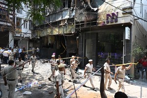 图： 6月3日，在印度新德里，警察和相关工作人员在火灾事故现场调查。 