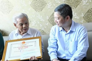 胡志明市市委宣教与民运处主任杨英德亲切问候陈皖长者的身体状况。