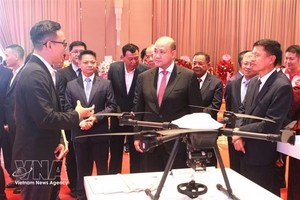 柬埔寨副首相洪玛尼（中）听取Metfone Express介绍无人机货运设备。 