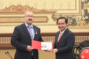 胡志明市人委会主席阮文得向俄罗斯驻本市总领事萨德科夫·蒂米尔颁授胡志明市纪念章。 