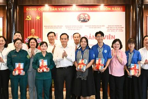 胡志明市市委书记陈留光与市领导向新党员赠送贺礼。图：越勇