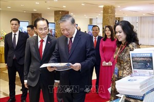 党中央总书记、国家主席苏林在会议间隙观看一些对外图片。图:统一/越通社 