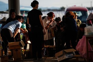7月30日，在日本熊本县一处避难所，民众领取救灾物资。 新华社记者 贾浩成 摄
