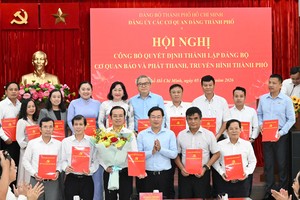 胡志明市市委常务副书记黎国峰向各位同志颁授决定并送花祝贺。图：越勇