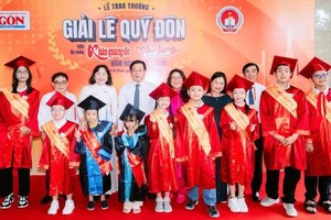 党中央委员、胡志明市市委常务副书记黎国峰，《西贡解放报》编辑部代表以及2025-2026学年黎贵惇奖获奖学生合影。图：国庆 