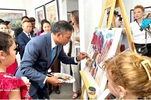 画家吴德煌在8月15日的展览现场演示在鼠皮纸上作画。