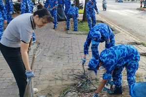 第三海警区司令部干部、战士与当地居民清理环境。