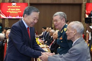 党中央总书记、国家主席苏林和获得党龄纪念章的党员握手。