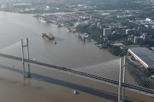 西贡河步行桥主跨拖运船队在柴腊河上经过平庆桥区域，继续朝富美桥方向前进。