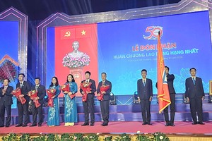 政府副总理黎进珠向胡志明市师范大学领导集体颁授一等劳动勋章，教育与培训部副部长阮氏娟清献花祝贺。