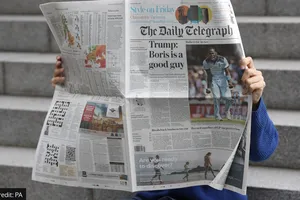 Độc giả xem báo của The Telegraph. Ảnh: JONATHAN BRADY/ PA WIRE 