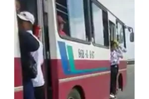 Hình ảnh các em học sinh đu bám trên của xe buýt rất nguy hiểm.