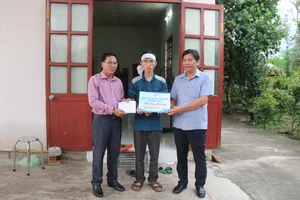 Đại diện Công ty TNHH MTV Xổ số kiến thiết Bình Thuận trao học bổng cho 2 anh em mồ côi trong vụ tai nạn