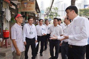 Chairman of District 7 People’s Committee Le Hoa Binh (R) mobilizes residents not to encroach roads and pavements to do business in March (Photo: SGGP)