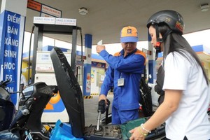 A customer fills gasoline E5 at a station in HCMC (Photo: SGGP)