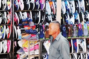 Shoes faking famous brand names are sold rampantly in the market (Photo: SGGP)