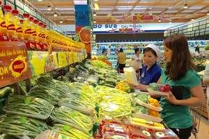 A customer buying vegetables at a supermarket in HCMC (Photo: SGGP)