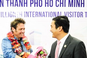 Mr. Bui Ta Hoang Vu, director of the Department of Tourism, congratulates the six millionth visitor to HCMC this year on December 15 (Photo: SGGP)