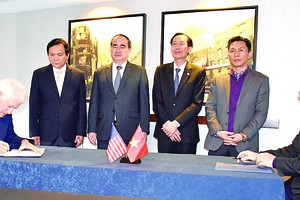 Director of HCMC National University Huynh Thanh Dat (R) and Principle of UCLA Gene D.Block sign a cooperation agreement in Washington D.C. on December 17 (Photo: SGGP)