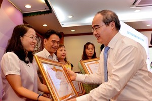 HCMC Party Leader Nguyen Thien Nhan gives certificates of merit to teams for well implementing propaganda and education work in 2017 at a conference on January 11 (Photo: SGGP)