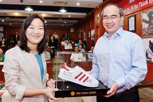 HCMC Party Chief puts his signature to shoe products of Pou Yuen Vietnam (Photo: SGGP)