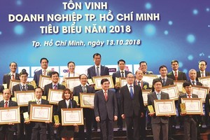 HCMC Party leader Nguyen Thien Nhan and chairman of HCMC People’s Committee Nguyen Thanh Phong congratulates oustanding businesses 2018 in HCMC on October 13 (Photo: SGGP)