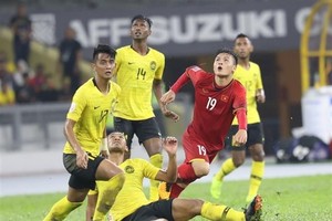 Nguyen Quang Hai (shirt no.19) is surrounded by Malaysian players (Source: VNA)