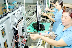 Workers assemble televisions at a Vietnamese firm. (Photo: SGGP)