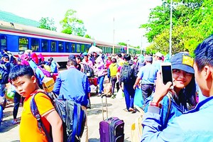 Passengers travel by bus to move across the derailment spot in Binh Thuan province on January 27 (Photo: SGGP)
