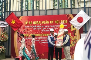 Deputy chairman  of HCMC People's Committee Tran Vinh Tuyen (L) gives workers of Ben Thanh-Suoi Tien metro project New Year presents (Photo: SGGP)